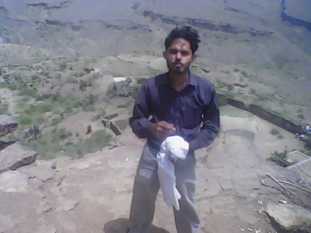 Shoaib was eating Chips and a valley view behind him