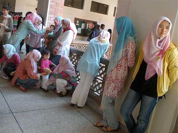 Chinese national ladies playing with their children at the corridors during the Grand Exhibition held at International Islamic University